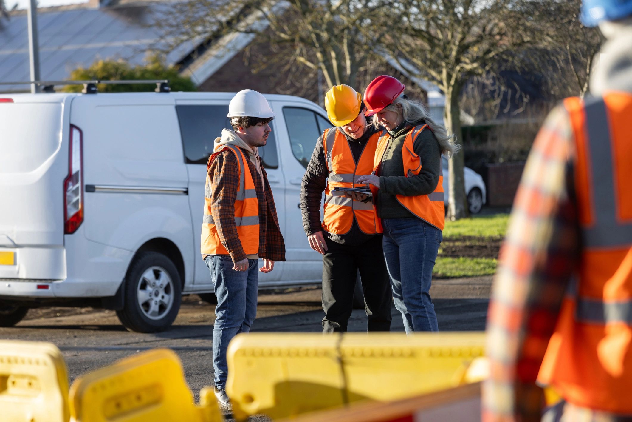 Assessor briefing candidates with tablet and documentation